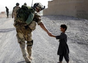 Un soldato che tende la mano ad un bambino afgano
